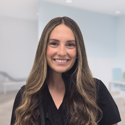 Smiling brunette woman with long wavy hair wearing black top, professional headshot